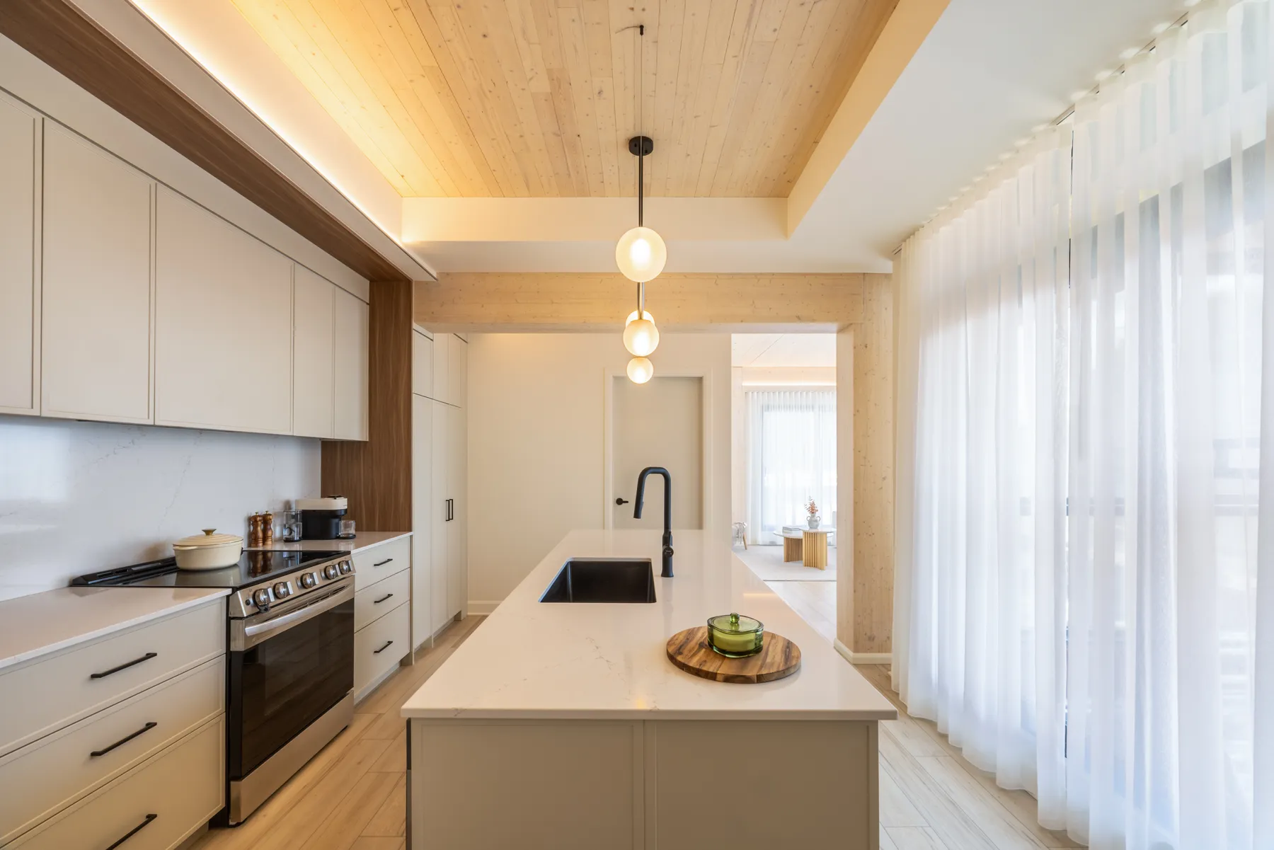 ANDAS kitchen with quartz island, shaker cabinets and exposed wood ceiling