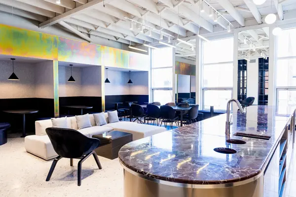 Lounge and kitchen island in marble under white beams