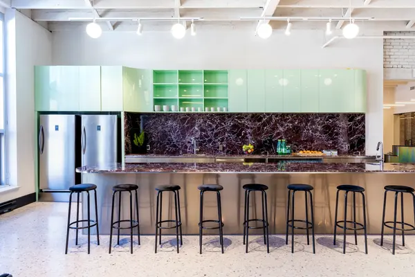 Kitchen with mint-green cabinets and a long marble bar
