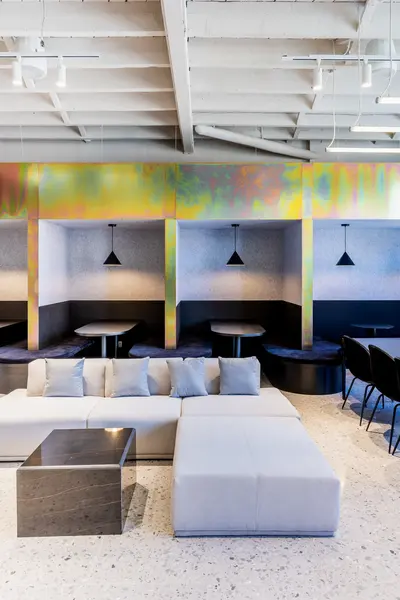 Booths under iridescent beams with black pendant lamps