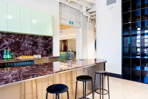 Marble kitchen counter with stools and black shelving