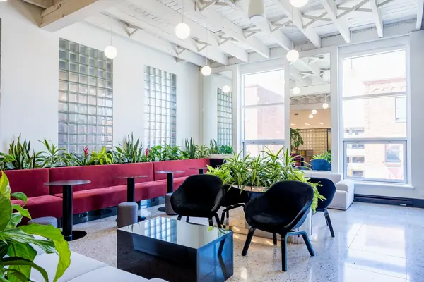 Lounge with burgundy banquettes, plants and glass-block windows